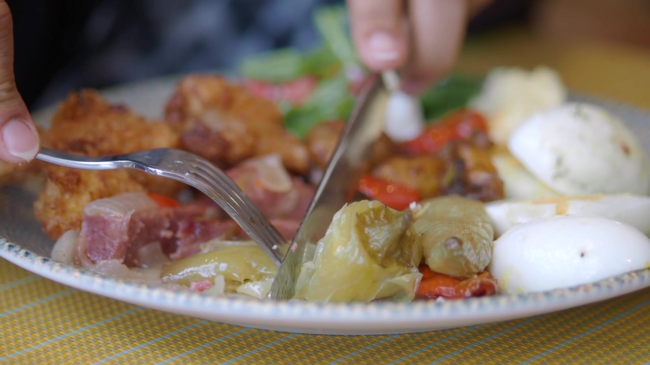 Primer plano de persona cortando un pimiento relleno en un plato