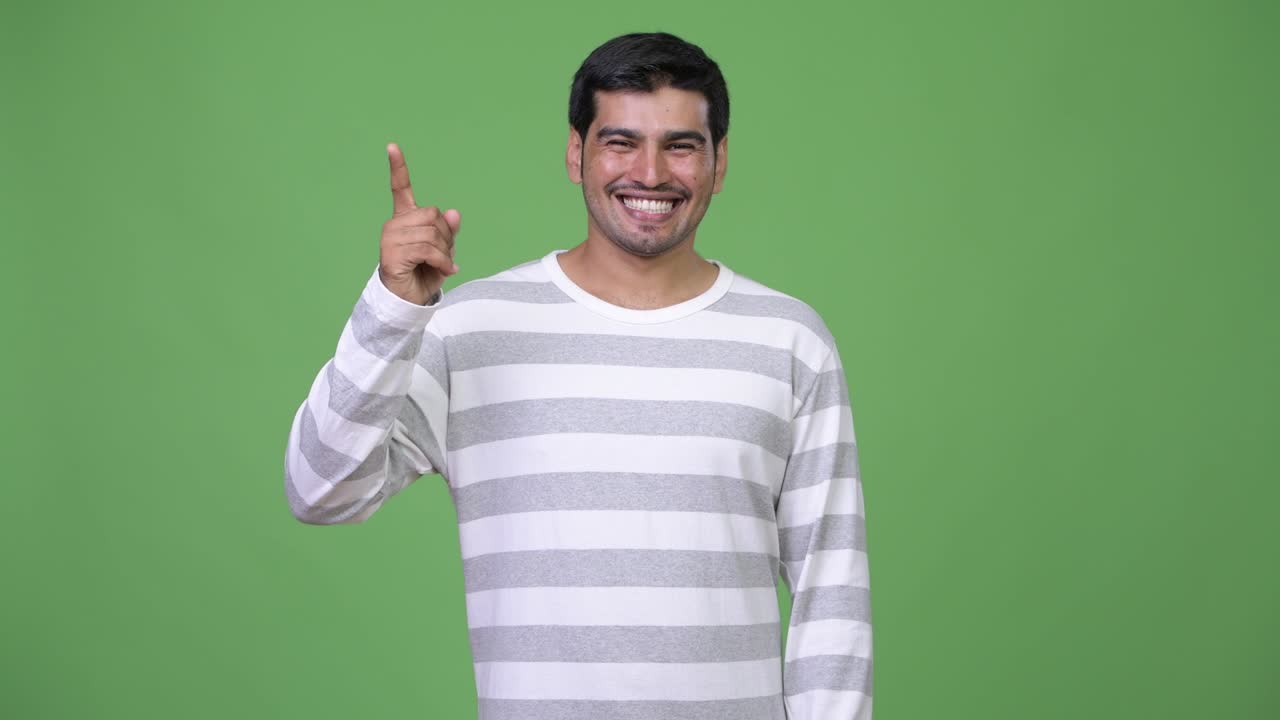 Young handsome Persian man pointing up