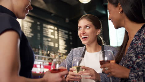 group of female friends meeting for drinks and socializing in bar after work