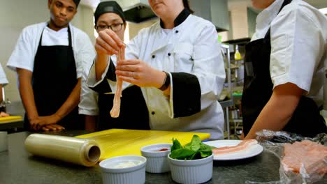 chef garnishing meat with in kitchen 4k