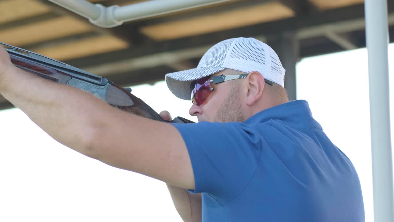 un deportista dispara con una escopeta de doble cañón, un campo deportivo para una prueba de tiro está disparando a un esquete volador