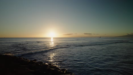 Majestic-Timelapse-of-sunset-over-horizon-of-Honololu,-Hawaii-with-cruise-ship-passing-in-front-of-the-setting-sun