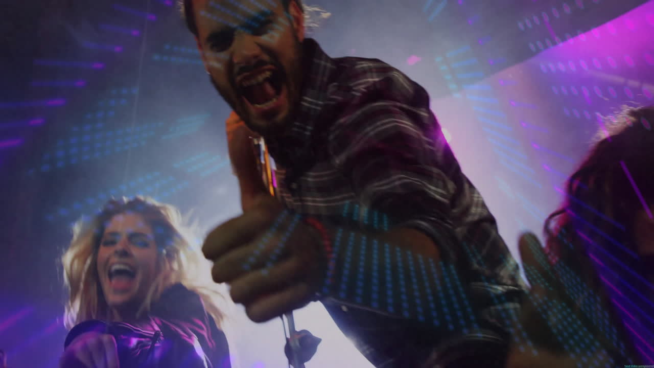 male singer leaning into crowd with microphone onstage, featuring LED waveforms for music marketing