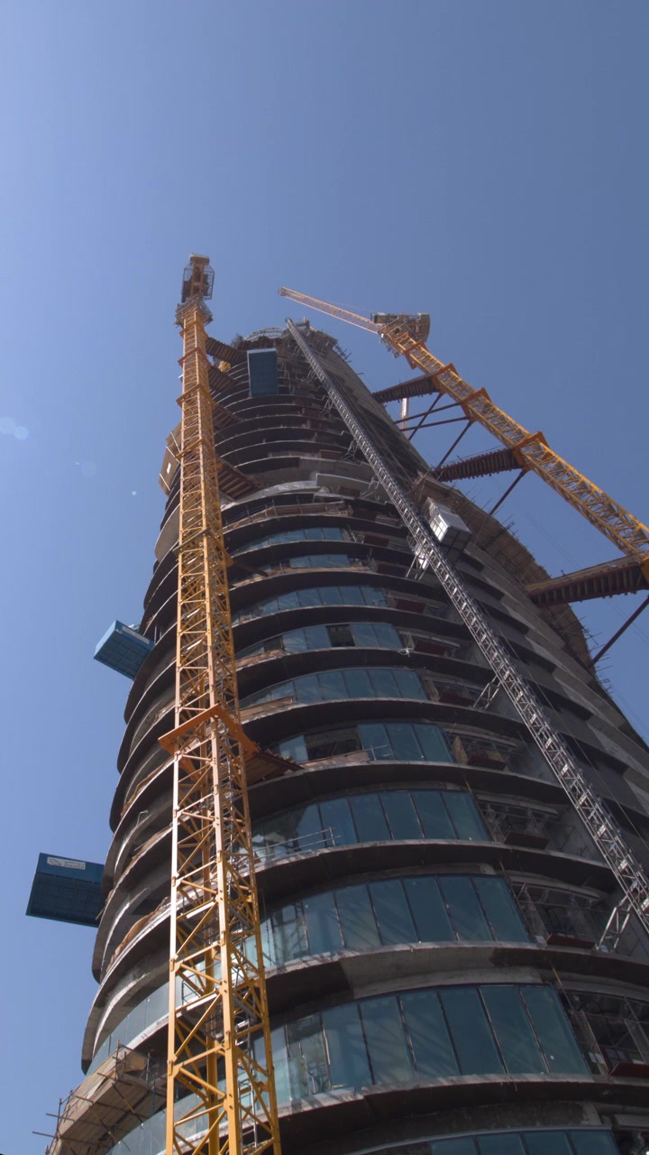 Construcción de un moderno rascacielos con grúas torre