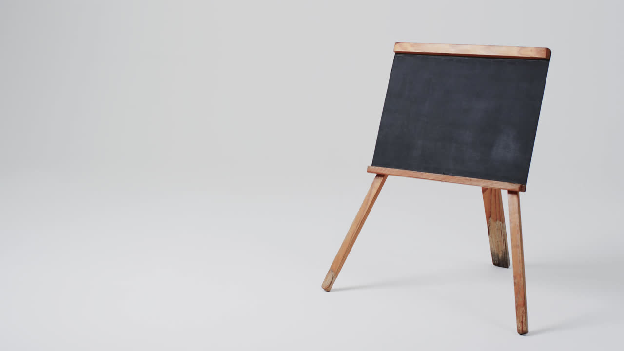 Video of blackboard sign on wooden stand with copy space on white background
