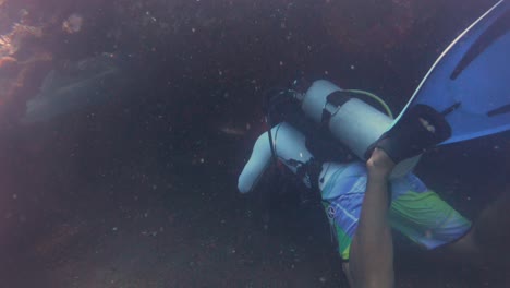 buzo entrando en el naufragio del barco hundido uss liberty scuba diving en bali, indonesia