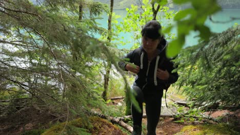 Hiking-woman-walk-with-a-hiking-backpack-in-spring-green-forest