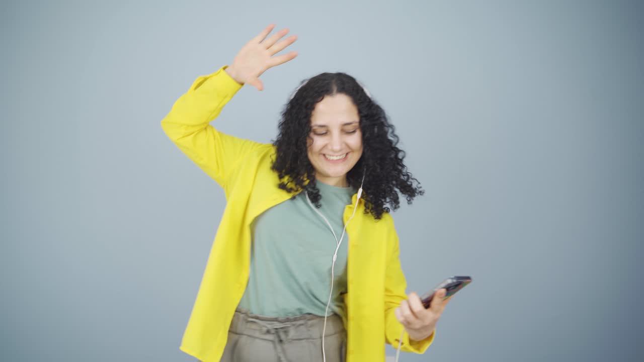 Giovane donna che balla con il telefono in mano
