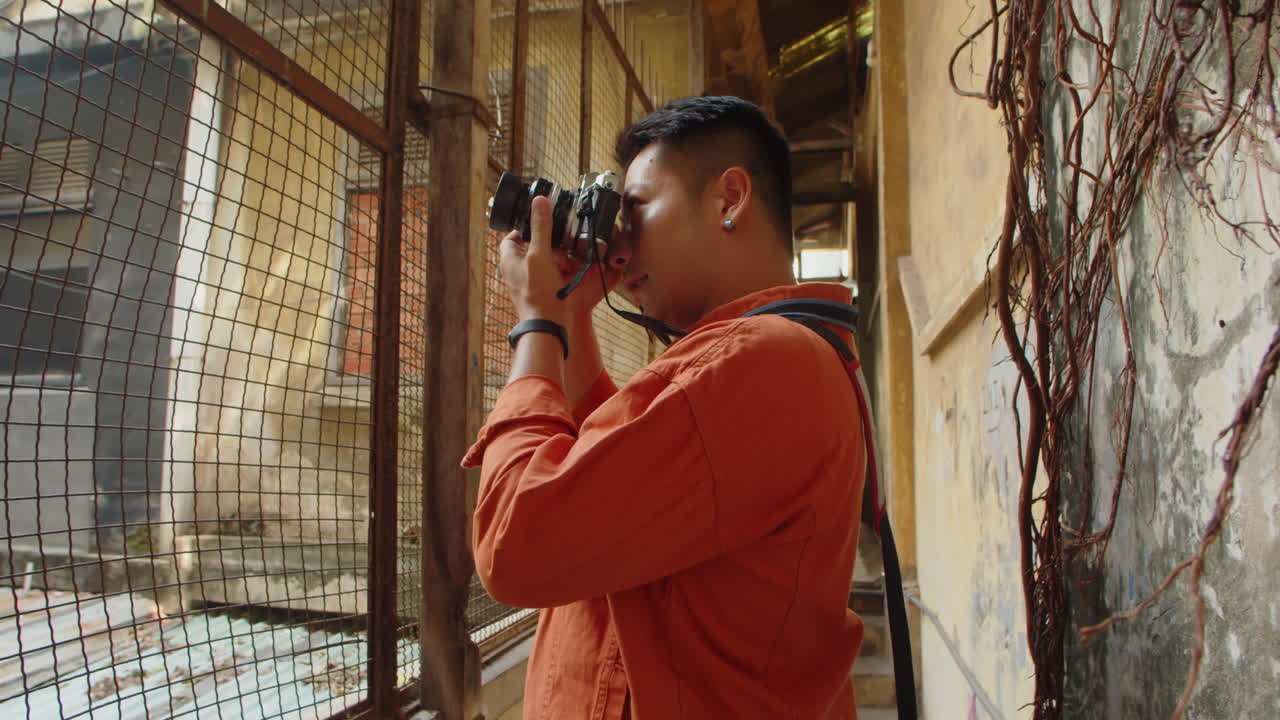 Asian Journalist Taking Pictures of Decaying House