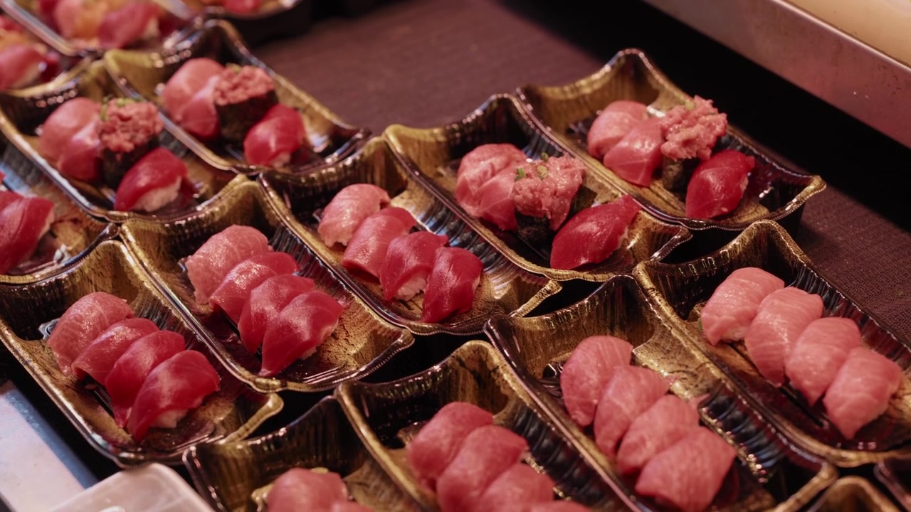Takeaway trays filled with assorted fresh tuna and otoro nigiri sushi at Japanese fish market
