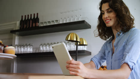 smiling woman using digital tablet at counter