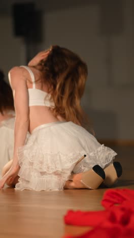 woman in white dress kneeling on stage