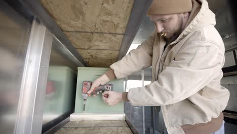 contractor installing shelves with cordless drill, static shot