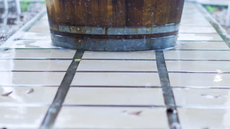 agua goteando frente al barril de vino en la pasarela de azulejos, clima lluvioso