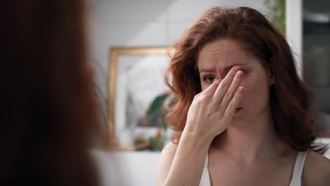 mujer caucásica con un gran dolor de cabeza de pie en el baño.