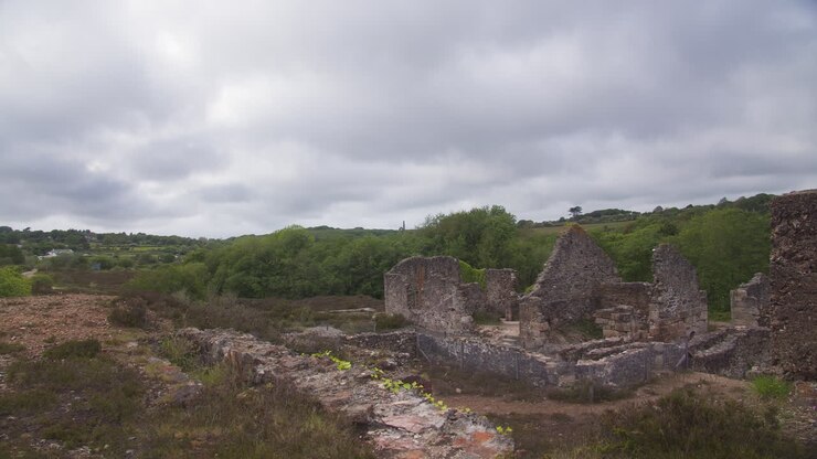 Ruínas da Mina de Poldice no vale sob céu nublado em Cornwall, Inglaterra, Reino Unido