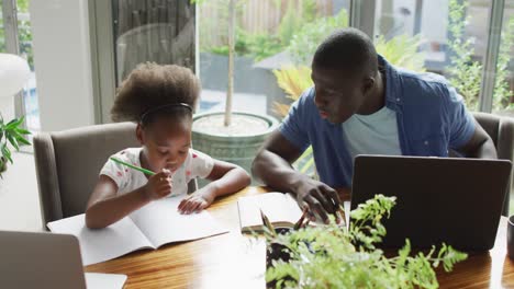 Video-Eines-Afroamerikanischen-Vaters-Und-Seiner-Tochter,-Die-Einen-Laptop-Benutzen-Und-Lernen