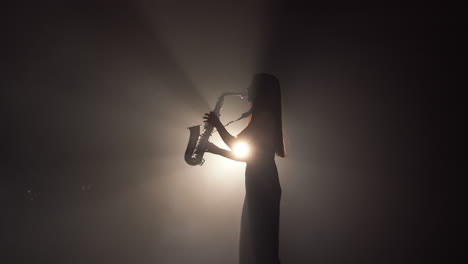 woman playing saxophone in silhouette