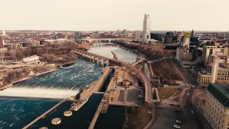 Toma-Aérea-De-Un-Dron-Del-Río-Mississippi-En-El-Centro-De-Minneapolis-Con-El-Puente-De-Arco-De-Piedra