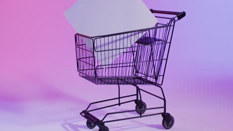 video of shopping trolley and canvas with copy space over neon pink background