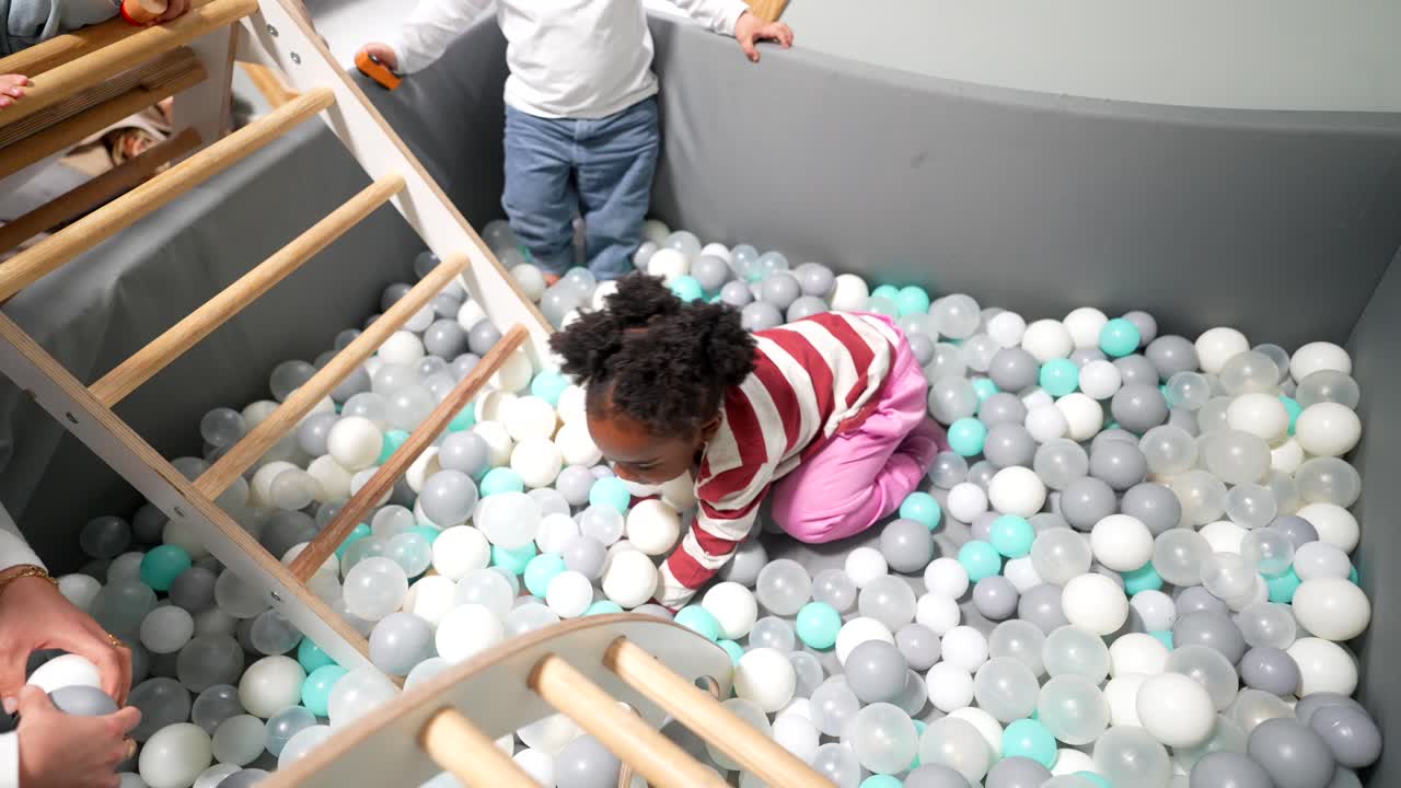 Happy Toddlers Playing and Crawling in a Colorful Ball Pit