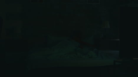 hermosa mujer rubia apagando la lámpara de noche en la acogedora sala de estar