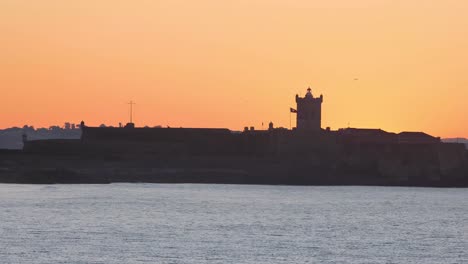 amazing view of saint julian fortress in carcavelos at huge sunrise