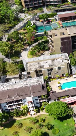 imágenes aéreas de un complejo de lujo en phuket, tailandia, mostrando piscinas, exuberante vegetación y arquitectura moderna bajo la luz del día