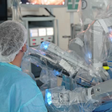 futuristic technological equipment in the surgery room. da vinci robotic arms in the modern clinic. doctor watching the process at the screen