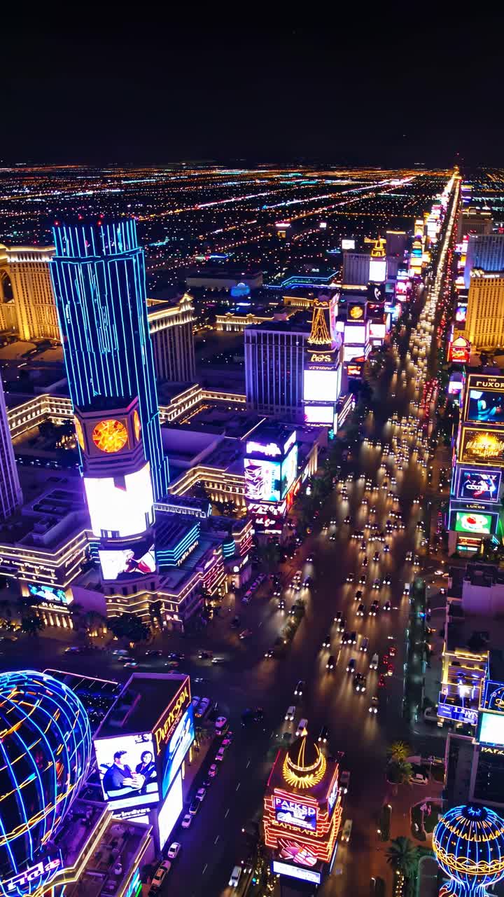 Aerial view of a vibrant cityscape at night, showcasing illuminated skyscrapers and bustling