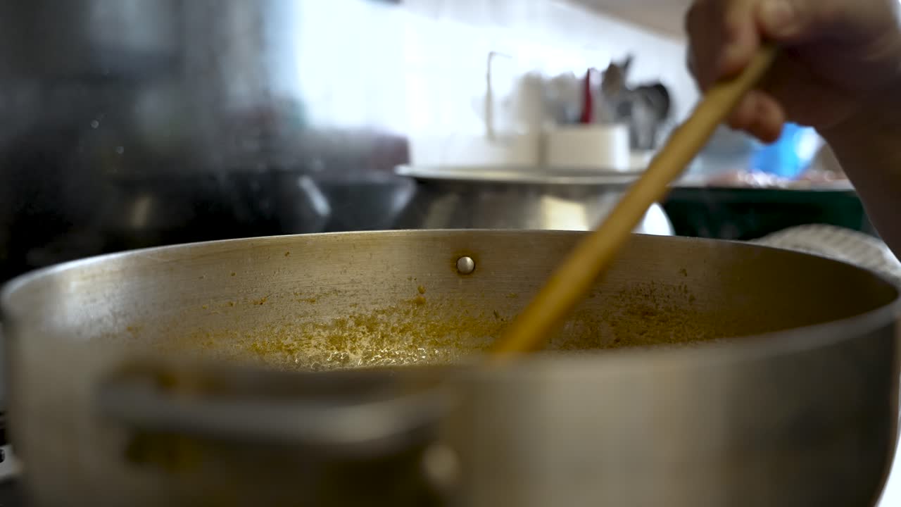 Wooden Spatula Stirring Curry Sauce In Large Pot
