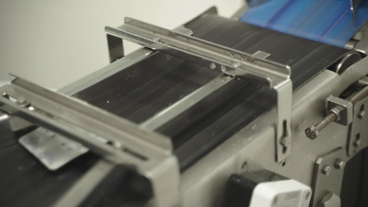 Automated production line processing medical blister packs in pharmaceutical factory.
