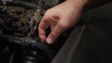 hands of mechanic checking a car engine