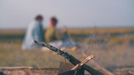 burning firewood in bonfire and happy lesbian couple on bank