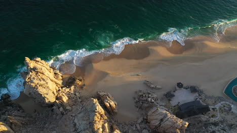 filmación cinematográfica de drones viniendo sobre las montañas en cabo san lucas méxico y luego enfocándose en las hermosas playas de playa el médano