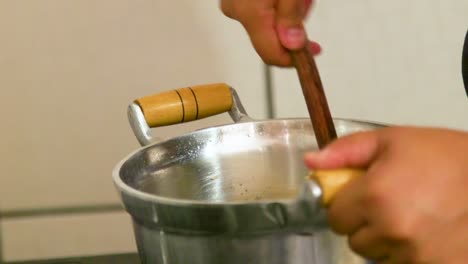 mujer sostiene una sartén mientras cocina arroz