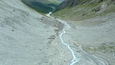 vuelo de drones sobre un sinuoso río glaciar a través de un valle alpino de alta montaña