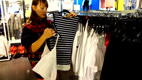 en las tiendas de europa, la chica elige la ropa.