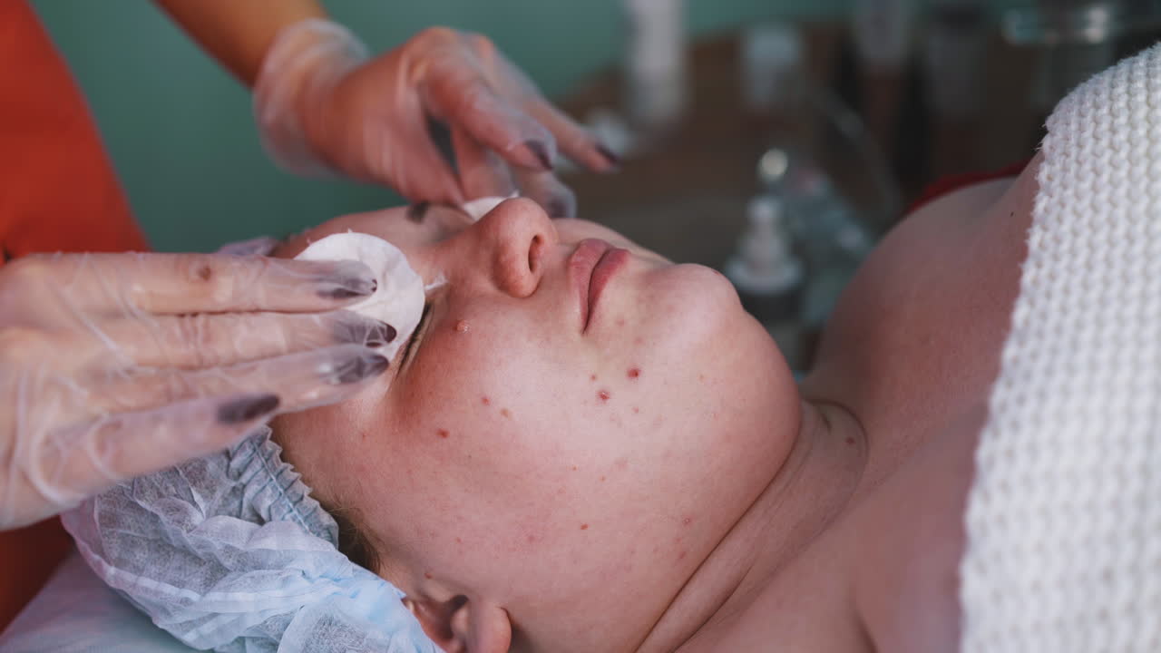 미용사가 플러스 사이즈 여성의 눈에서 메이크업을 제거합니다.