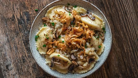 delicious pierogi with crispy onions and mushrooms on wooden table