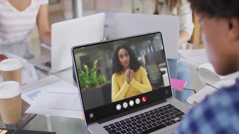 Mujer-Afroamericana-Usando-Una-Computadora-Portátil-Para-Videollamadas,-Con-Un-Colega-De-Negocios-En-La-Pantalla