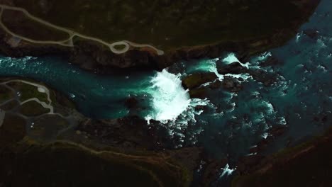 aerial rising top view over godafoss waterfall, iceland, on a cloudy and moody day