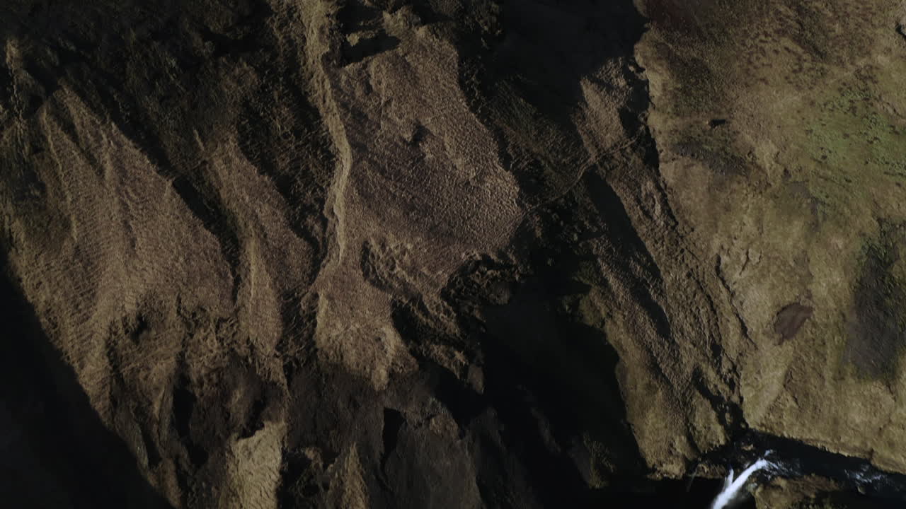 cascada kvernufoss corriendo por un acantilado cubierto de musgo durante la primavera en islandia