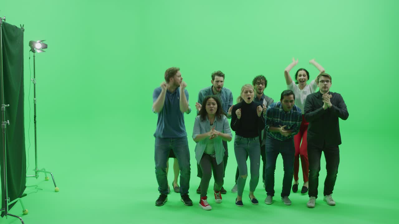 Studio Chroma Key a schermo verde: folla eterogenea di fan multietnici che esultano, saltano e applaudono con le mani in aria a un evento sportivo pubblico, concerto, festival, festa. Inquadratura frontale completa