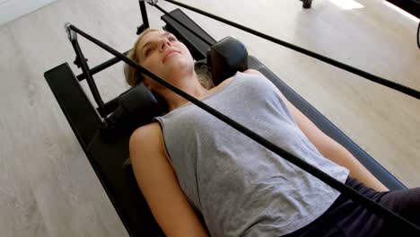 woman doing exercise with resistance bands on rowing machine 4k