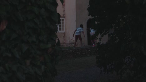 siblings enjoying outdoor activity - playing tennis in garden of manor house. - slow motion