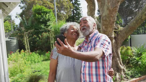 Animation-of-african-american-senior-couple-taking-selfie-in-garden