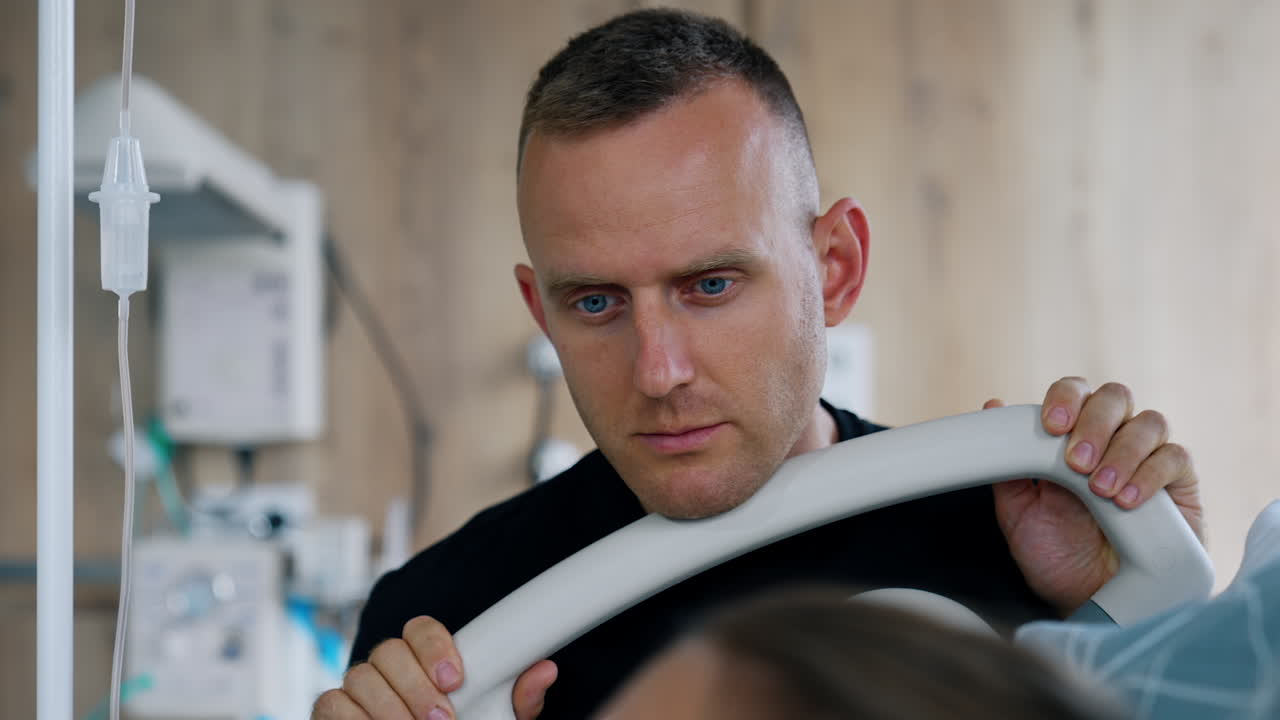 Caucasian man standing near the hospital bed of his wife delivering a baby. Partner childbirth in the modern clinics.