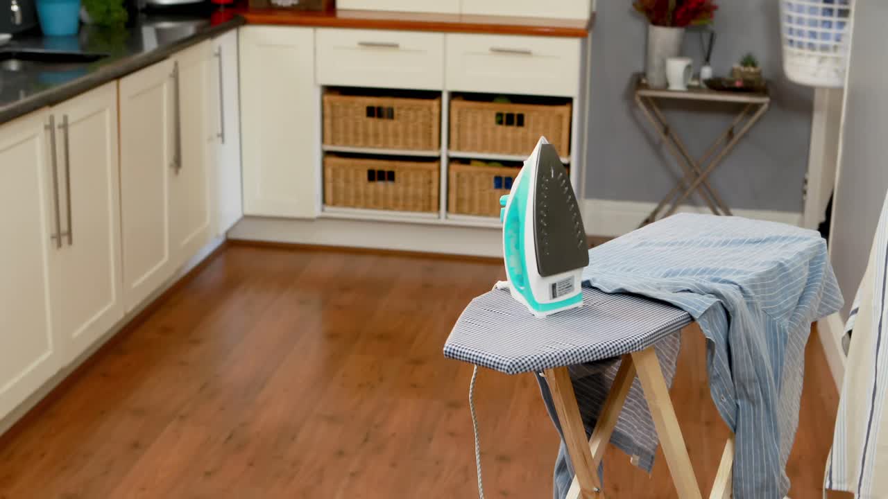 Uomo che tiene un secchio pieno di vestiti in cucina 4k