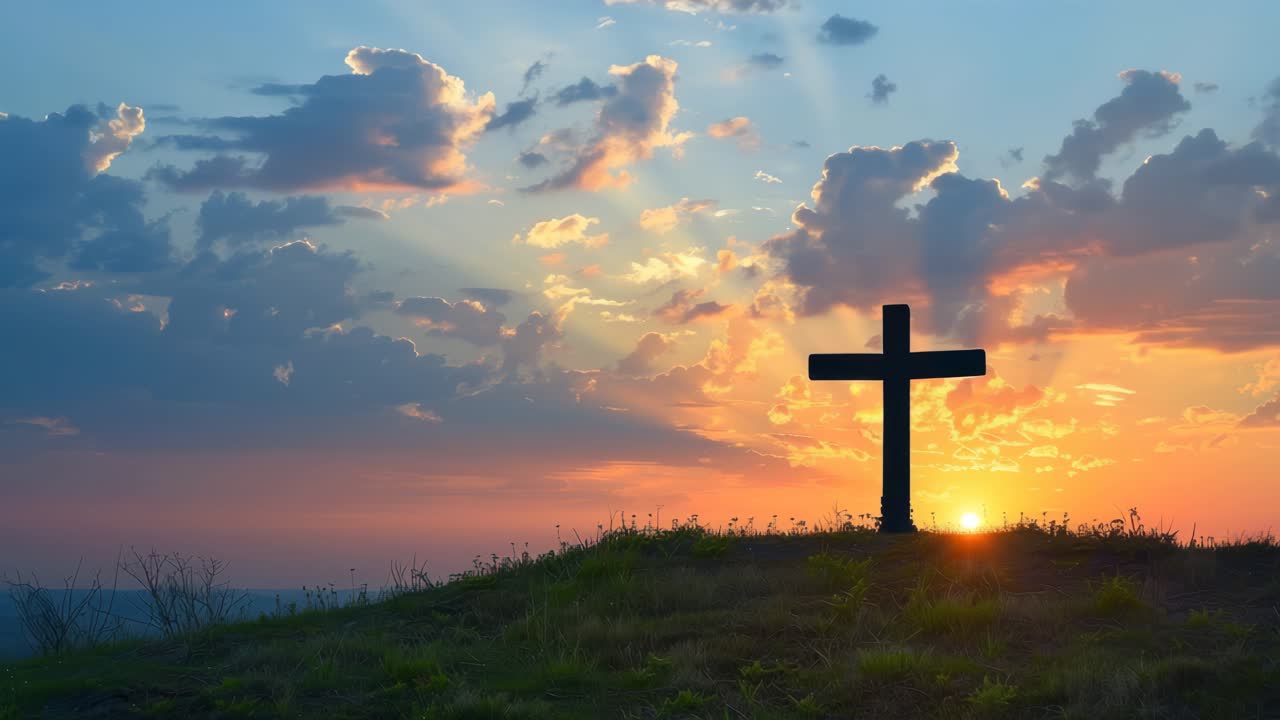 Silhouette of a cross on a hill at sunset, captured from a low angle